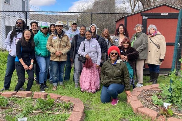 Ms. Delores McGruder, one of Teresa Davis's flow fund recipients, leads community members on a garden tour. Photo by Teresa Davis.